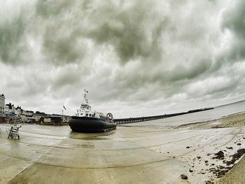 Boats in sea against cloudy sky