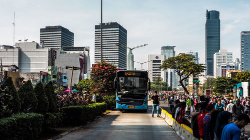People on street amidst buildings in city