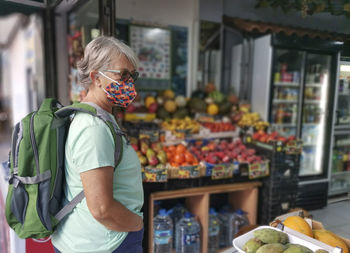 Full length portrait of woman standing at store