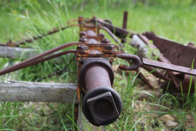 Close-up of rusty wheel on field