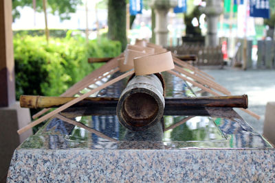 Close-up of water spraying on wood against built structure