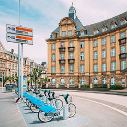 Bicycle by street against buildings in city