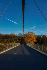 Bridge over road against blue sky