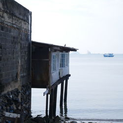 Building by sea against clear sky