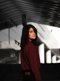 Beautiful young woman looking away while standing on land