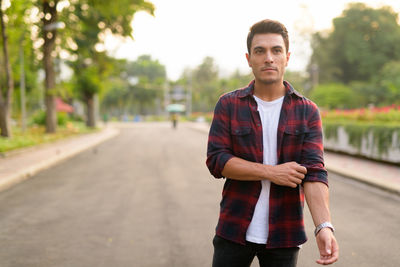 Portrait of young man standing on road