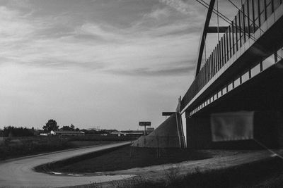 Road by bridge against sky in city