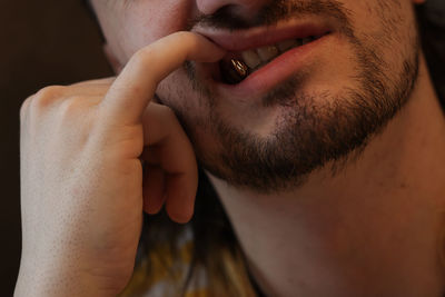 Close-up of young man showing gold tooth