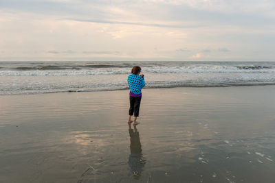Full length rear view of man standing on beach