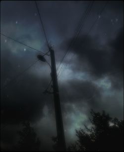 Low angle view of power lines against cloudy sky