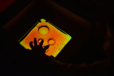 Close-up of yellow clock against black background