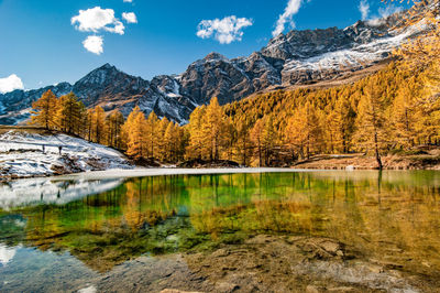 Scenic view of lake by autumn trees against mountains