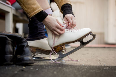 Close-up of woman putting on ice skates