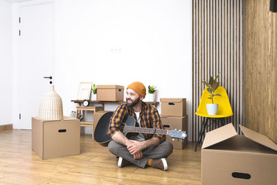 Mature man unpacking things from boxes while moving in new apartment.