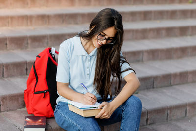 Young woman sitting on book