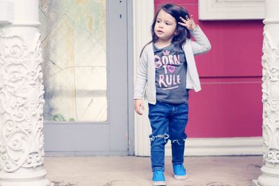 Cute girl standing against wall