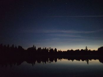 Scenic view of lake against sky at night