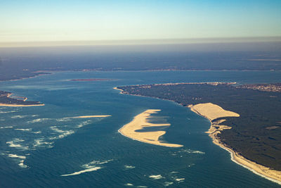 High angle view of city by sea against sky