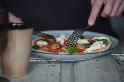 Close-up of human hands cutting food