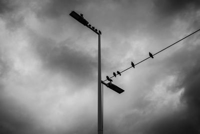 Low angle view of street light against cloudy sky