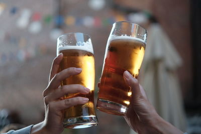 Close-up of hands holding beer glasses