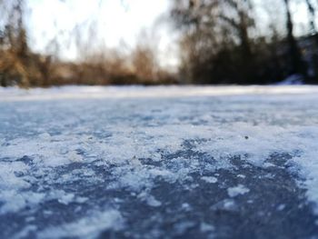 Surface level of frozen road against sky