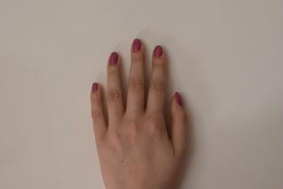 Close-up of woman hand against white background