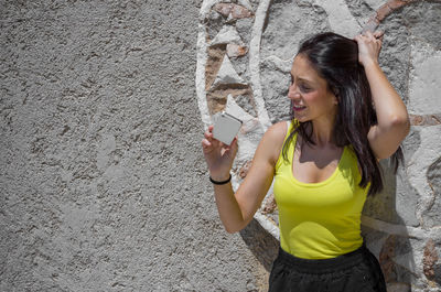 Portrait of smiling young woman using mobile phone