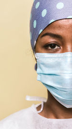 Portrait of doctor wearing mask against blue background