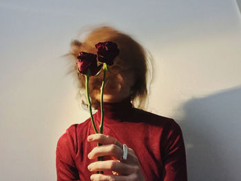 Portrait of young woman in motion with flowers and red shirt