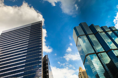 Low angle view of modern buildings against blue sky