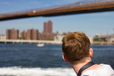 Rear view of man against river