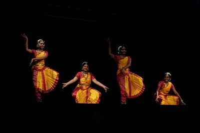 People dancing against black background