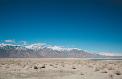 Scenic view of desert against blue sky