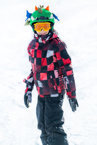 Portrait of boy in warm clothing on snow covered landscape