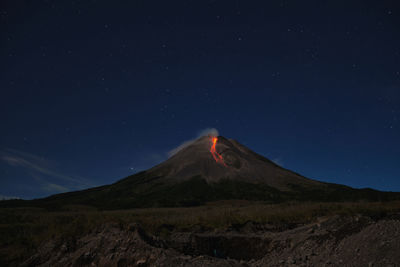 Scenic view of volcanic mountain against sky at night