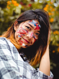 Close-up portrait of smiling young woman with face paint