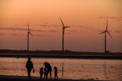 Silhouette people at beach during sunset