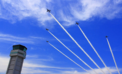 Low angle view of airshow against sky