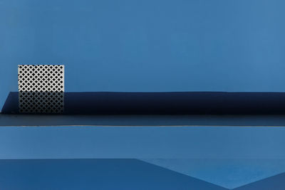 Close-up of blue table against wall
