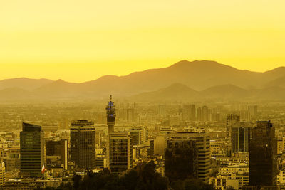 Buildings in city against sky during sunset