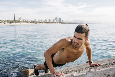 Young man looking at sea against sky