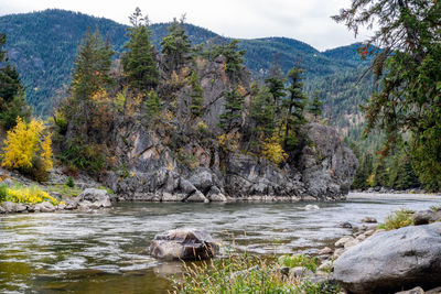 Scenic view of river by trees against mountains