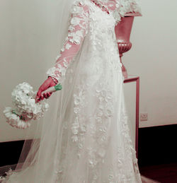 Low section of woman standing on flower bouquet