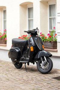 Motor scooter on street against building