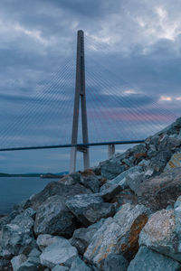 View of suspension bridge against cloudy sky