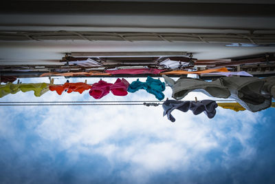 Low angle view of flags hanging against sky