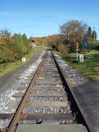 Railroad tracks amidst trees against sky