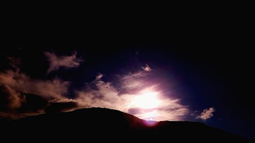 Low angle view of silhouette mountain against sky at night