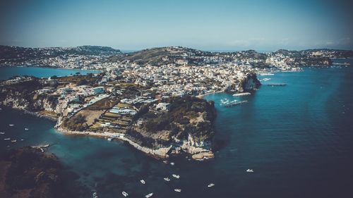High angle view of townscape by sea against sky